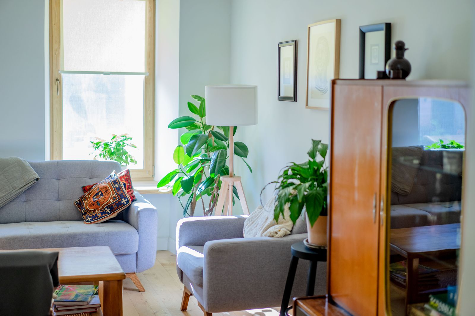 The same living room after the redesign, with an olive sofa, rug, art and lamps