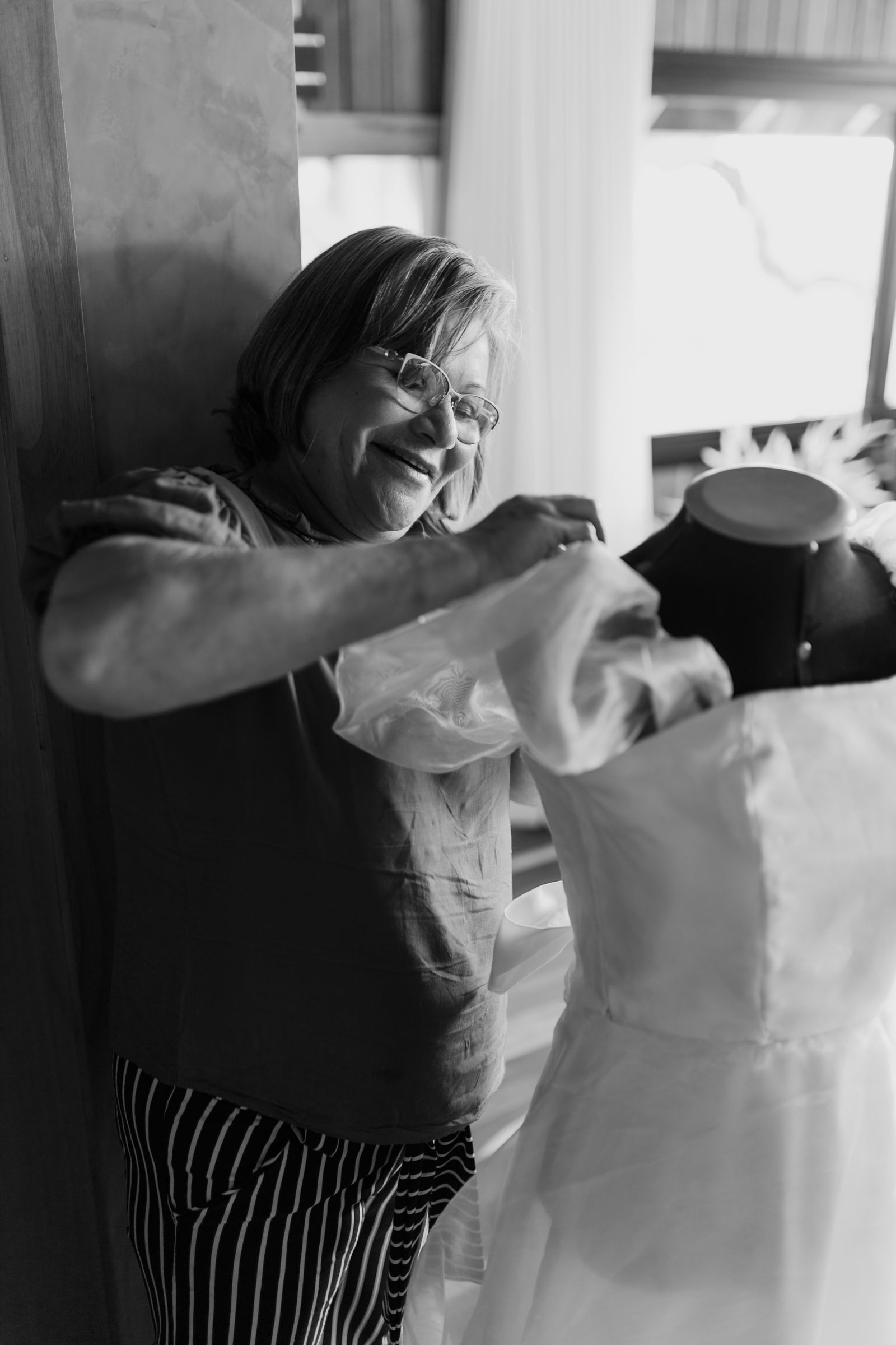 A wedding gown on a dress form with a tape measure and pins