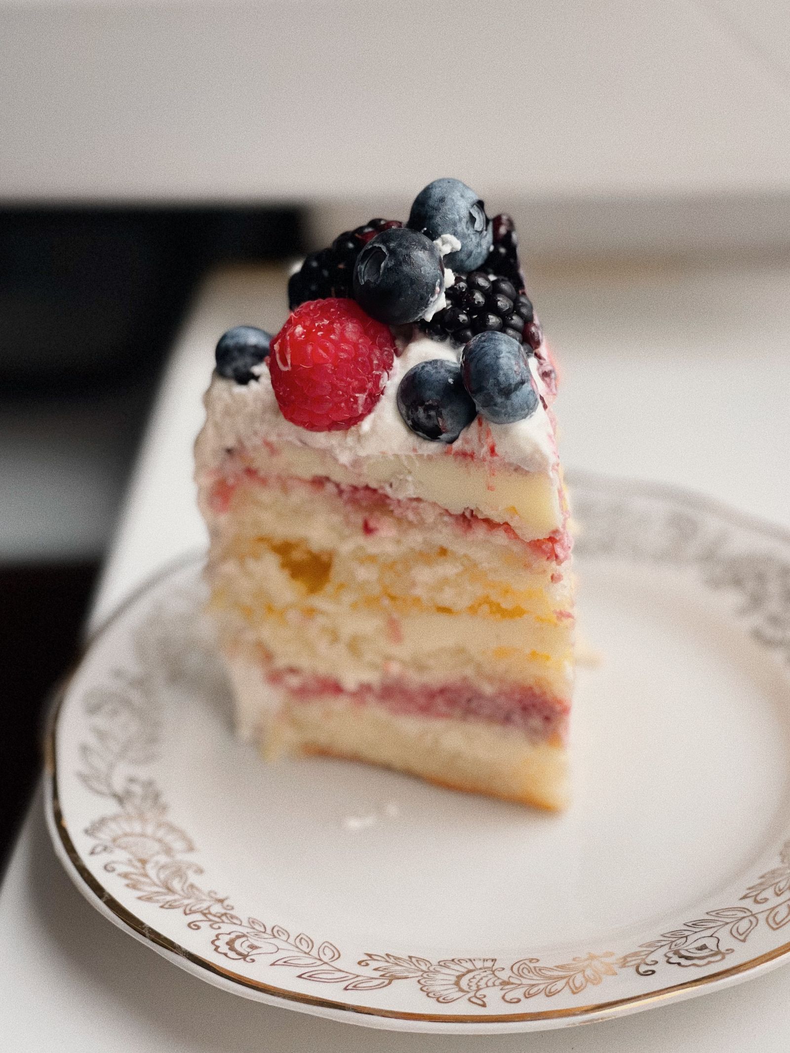 A layered sponge cake with berries on a cake stand
