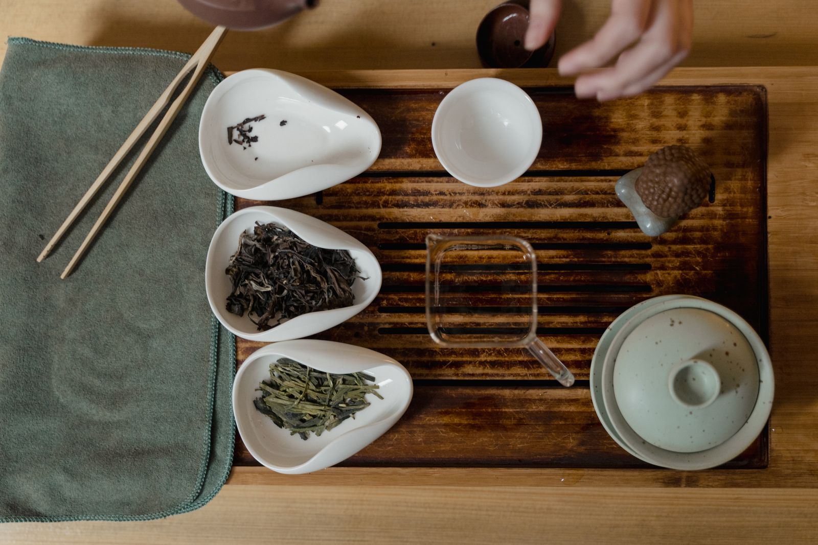Four tasting cups of different teas with their dry leaves in front