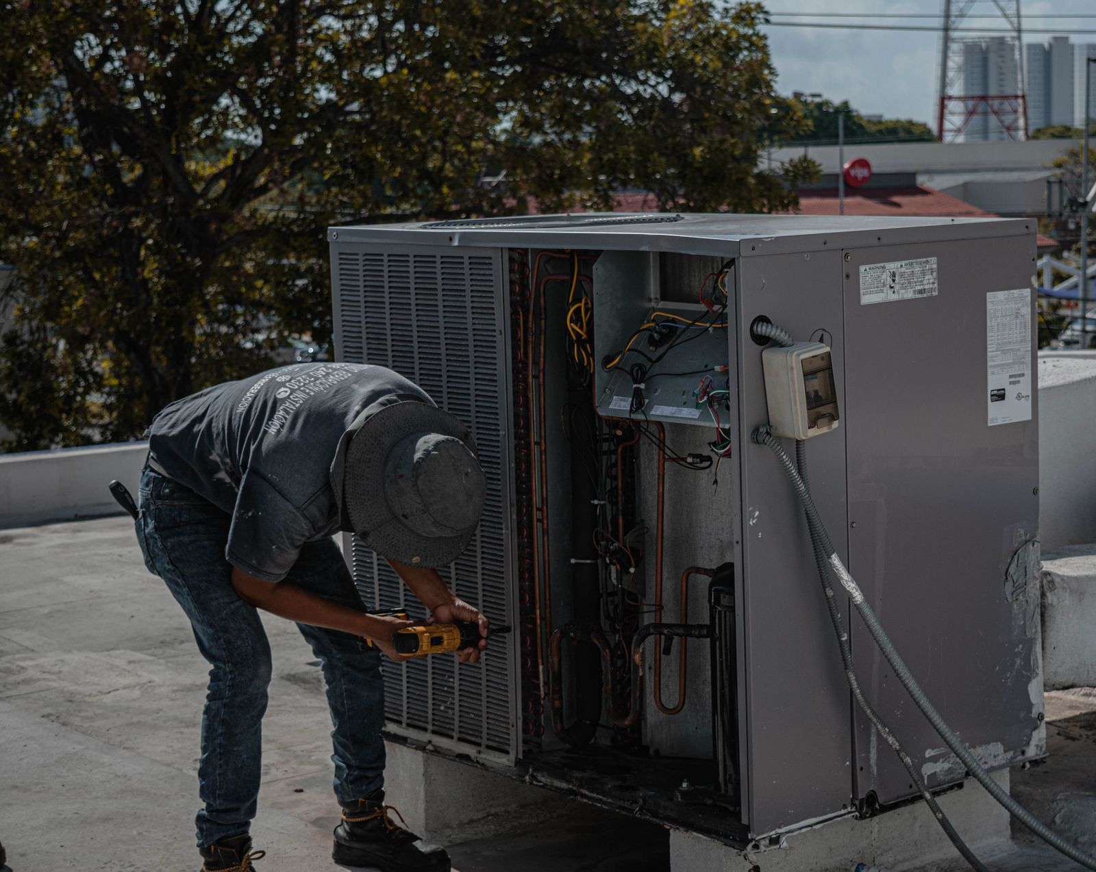 A technician checking an outdoor air conditioning unit