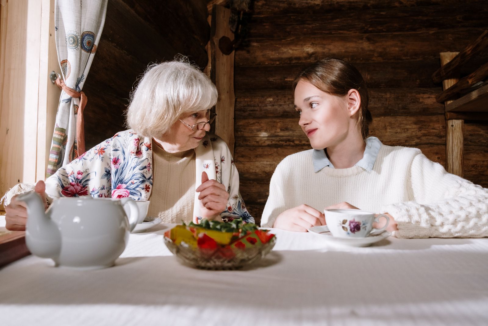 Illustration of a caregiver and an older woman sharing tea at home