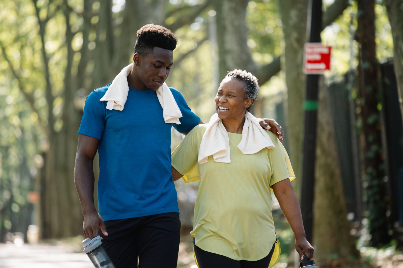 Illustration of a caregiver walking arm in arm with an older man in a park