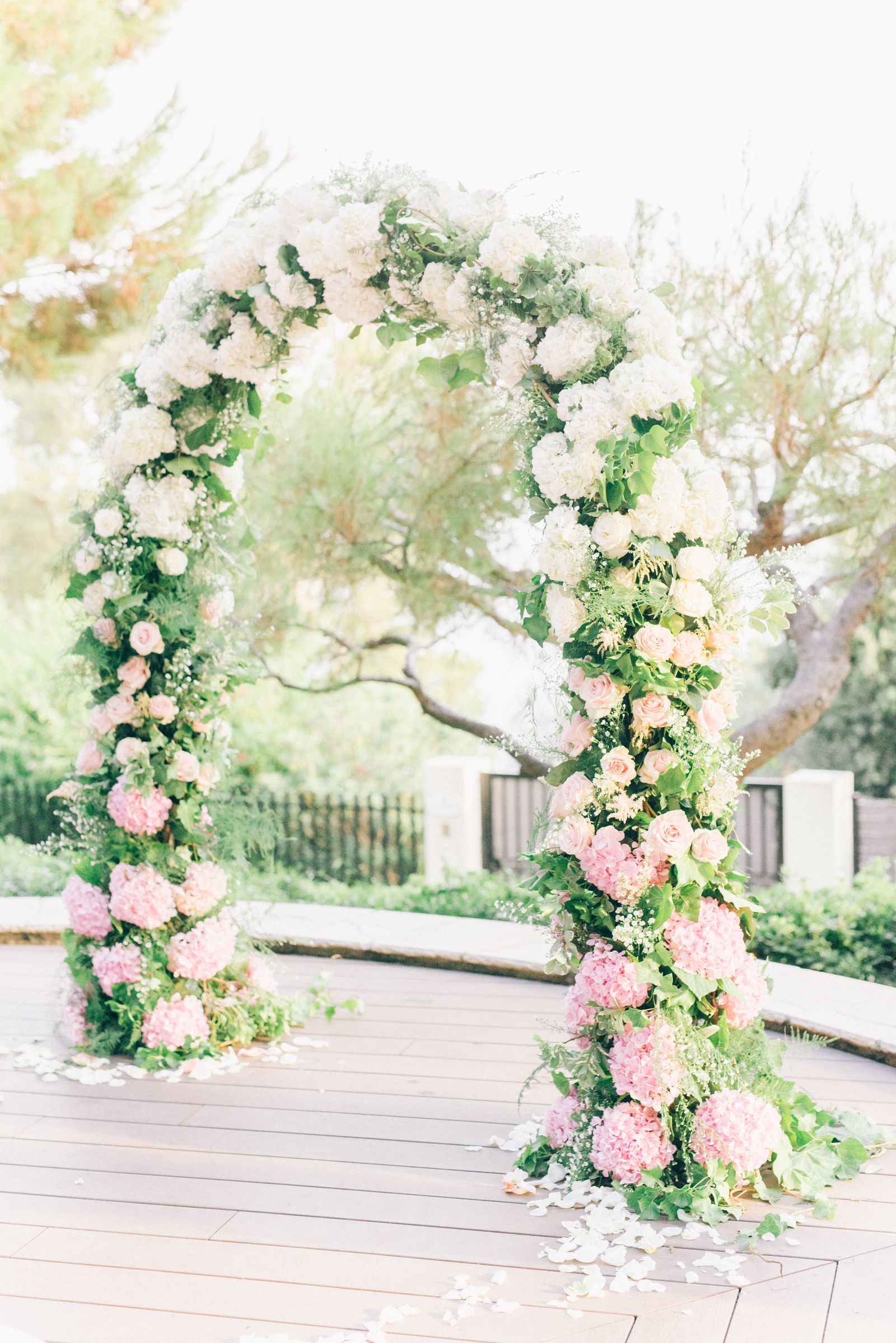 A couple under a floral wedding arch