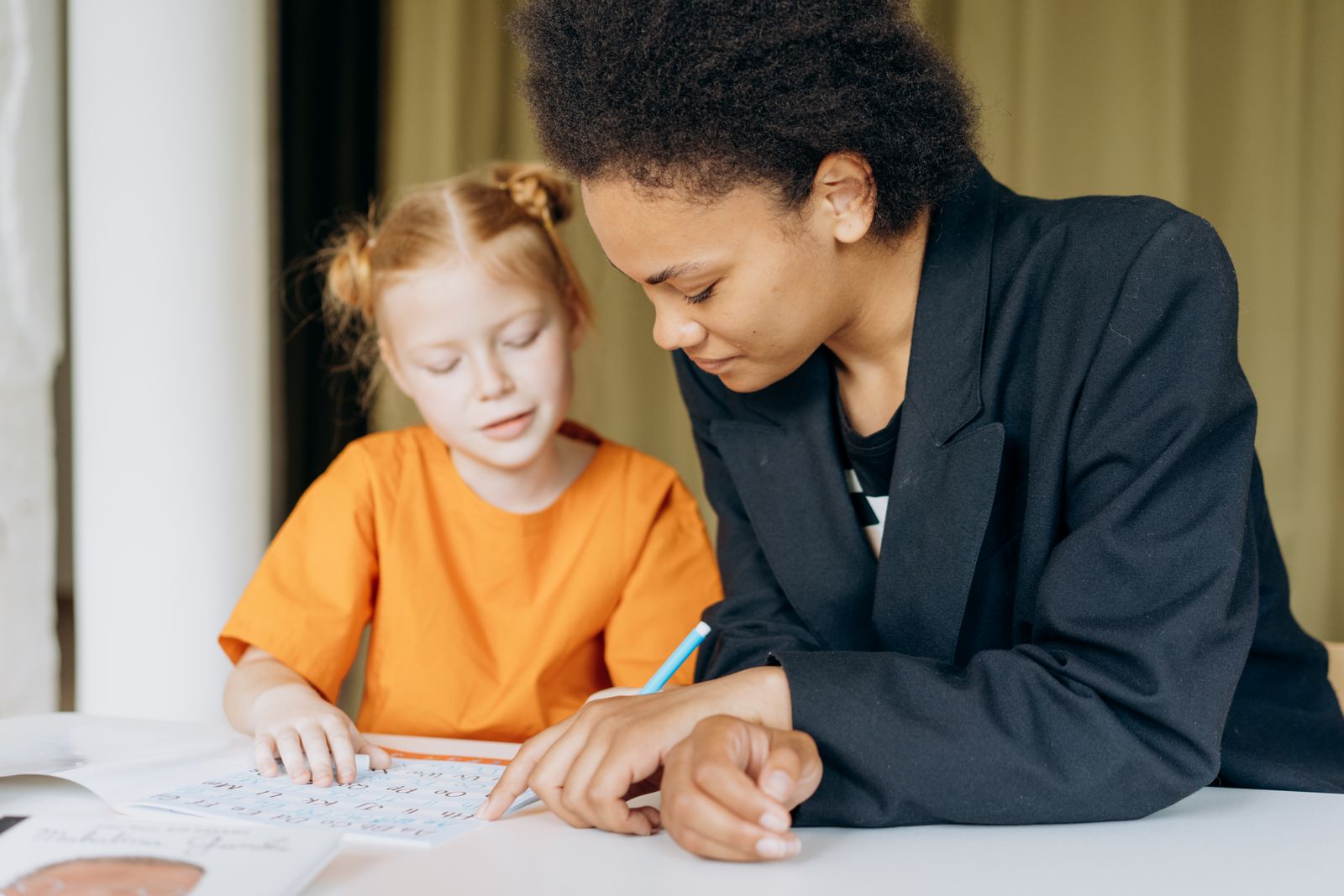Illustration of a tutor helping a child with homework at a desk
