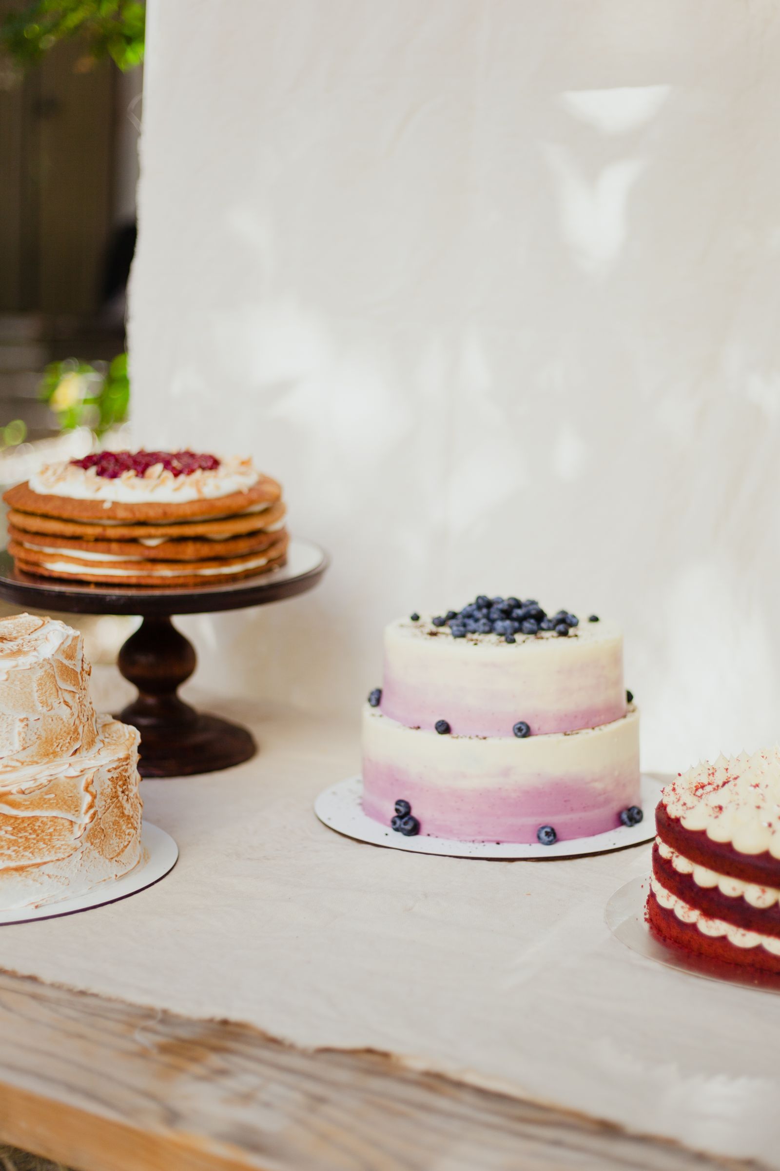 A layer cake with fresh berries on a cake stand