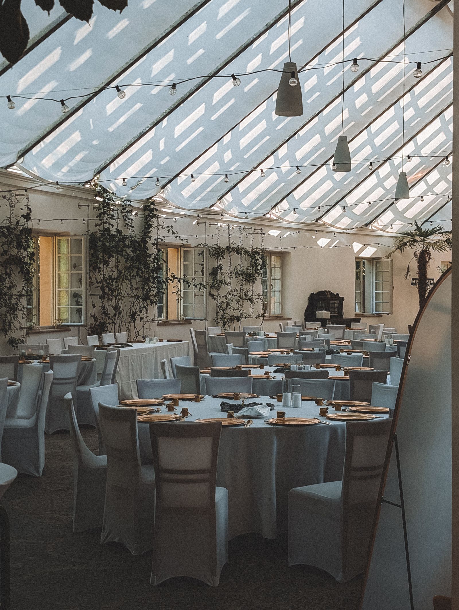 The main hall with arched windows, string lights and dressed tables
