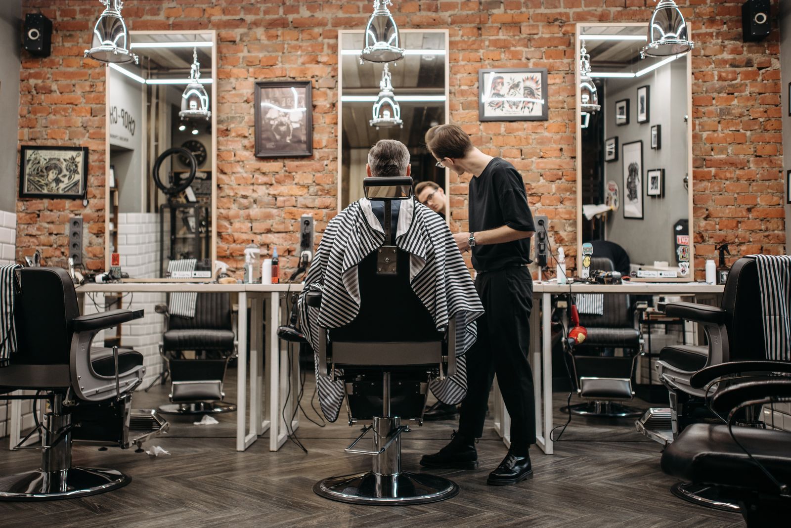 A barber cutting a client’s hair in the barber chair