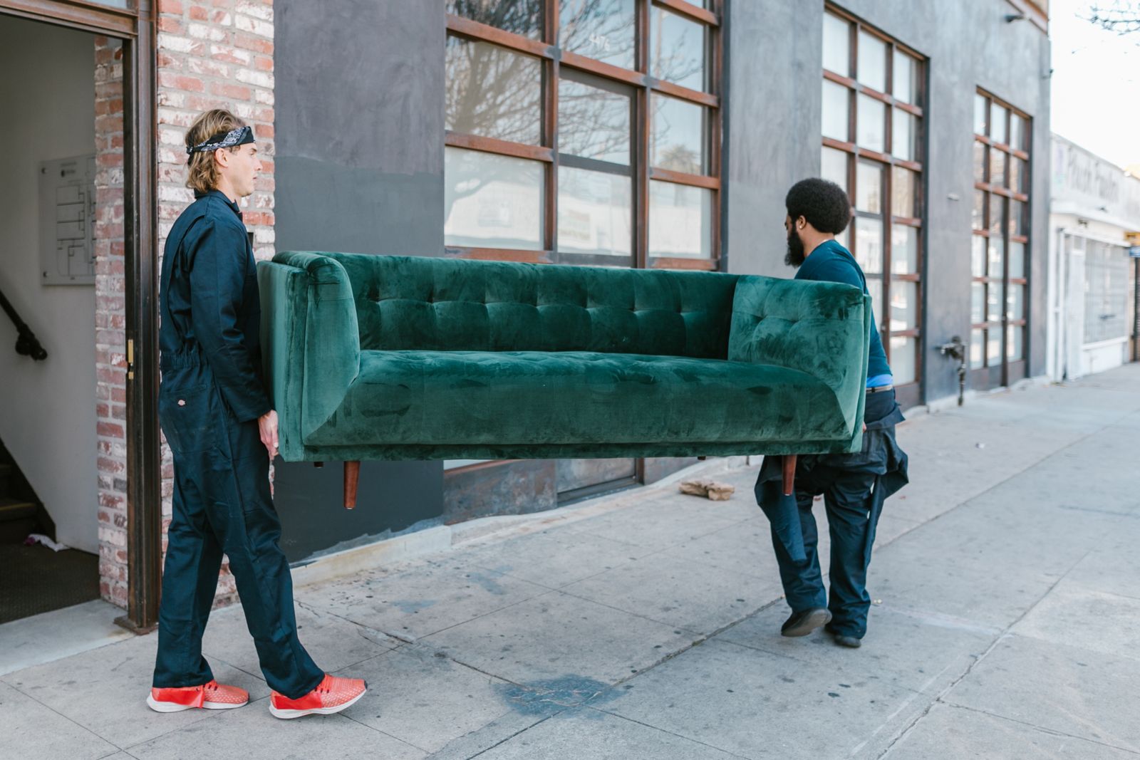 Two movers carrying a sofa to a moving truck
