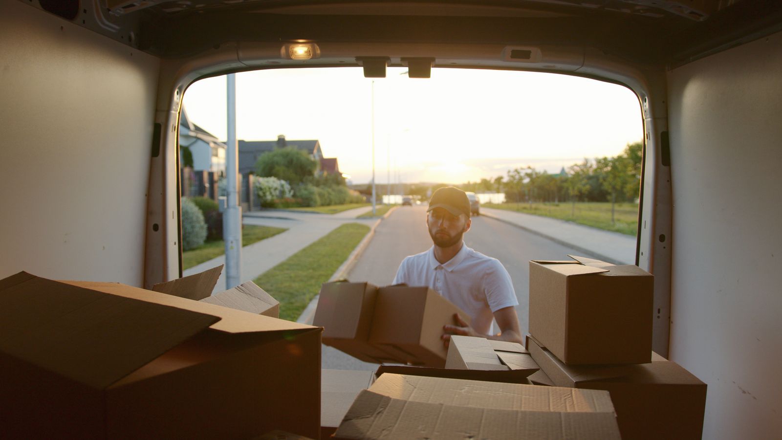 A loaded moving truck and a mover with a hand truck