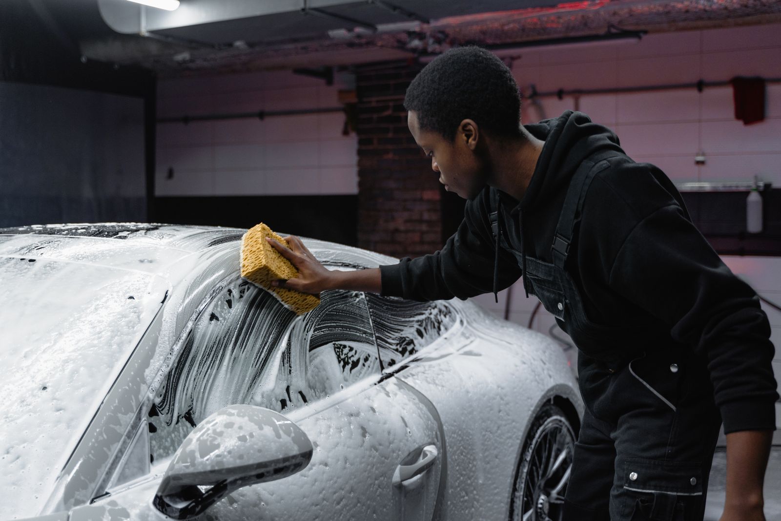 A detailer hand-washing a car