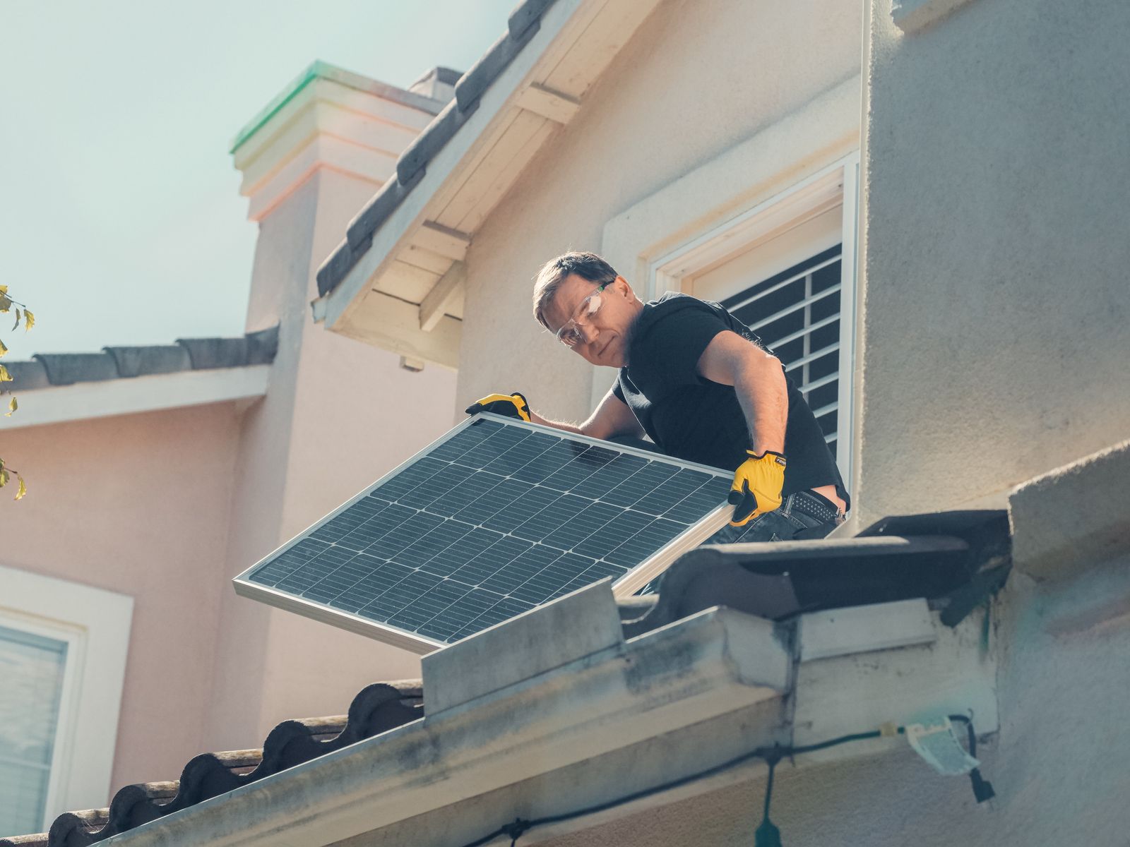 A home with solar panels on the roof and an installer