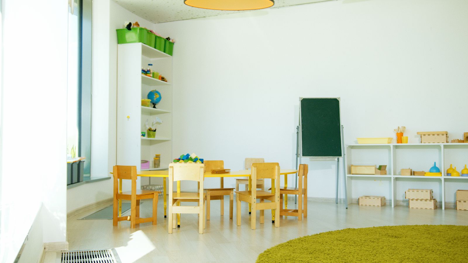 Illustration of a nursery room with small tables and chairs