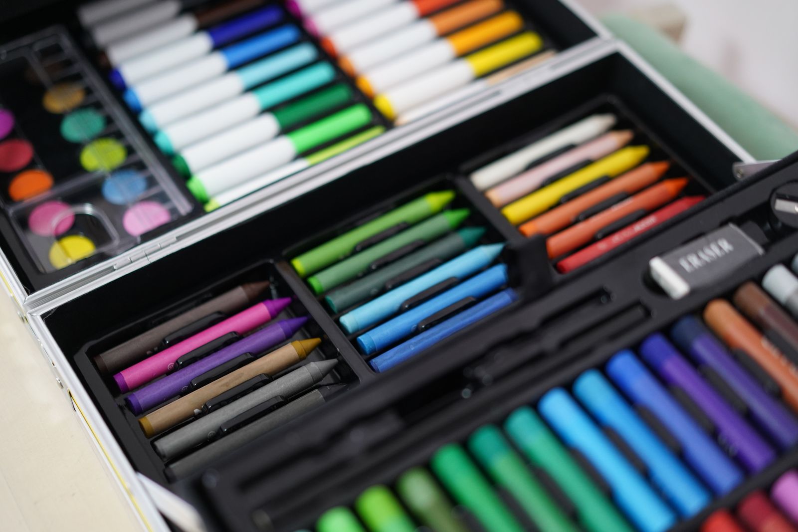 Illustration of an easel, paint pots and crayons