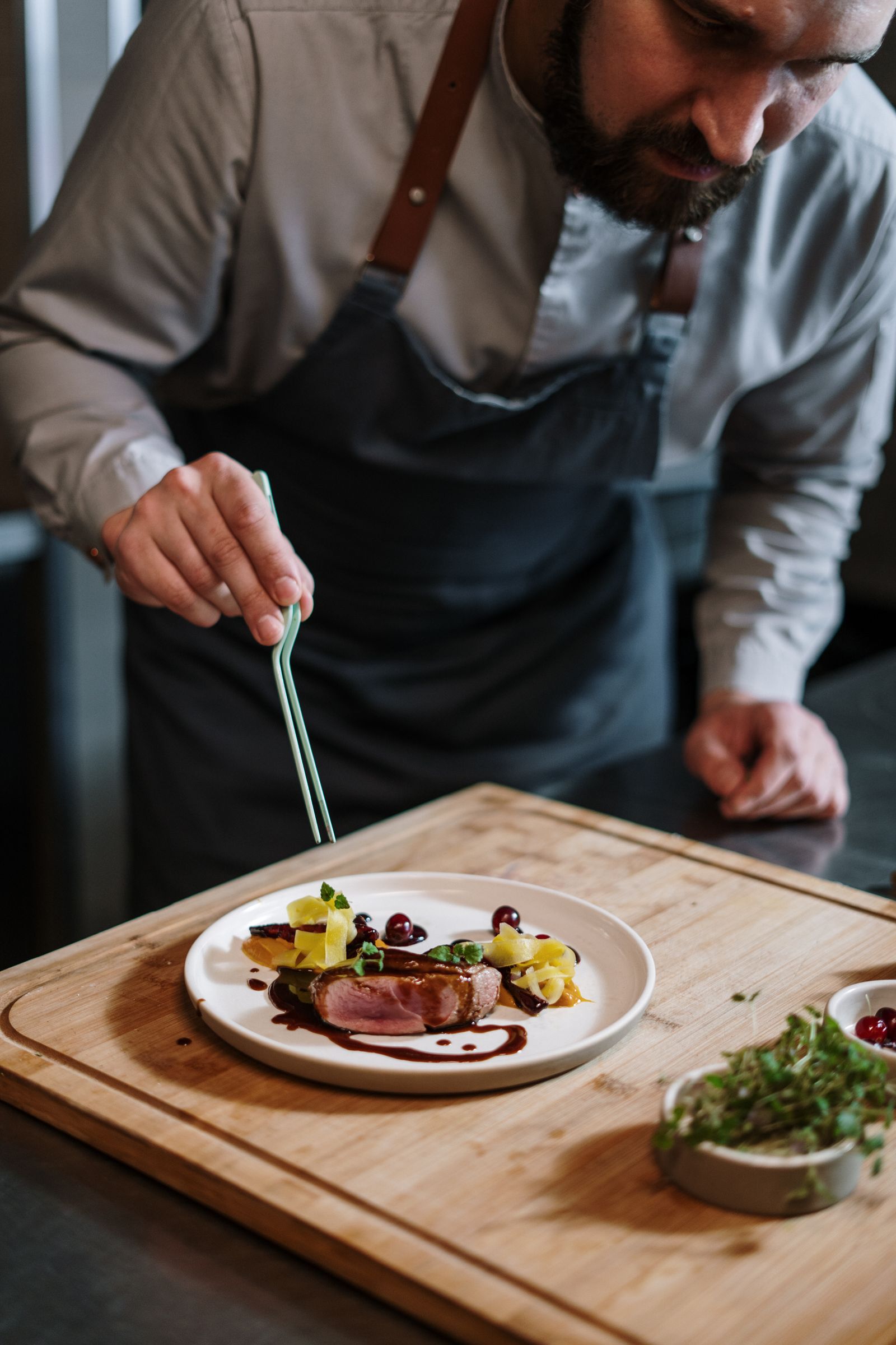 A chef plating dishes at the kitchen pass