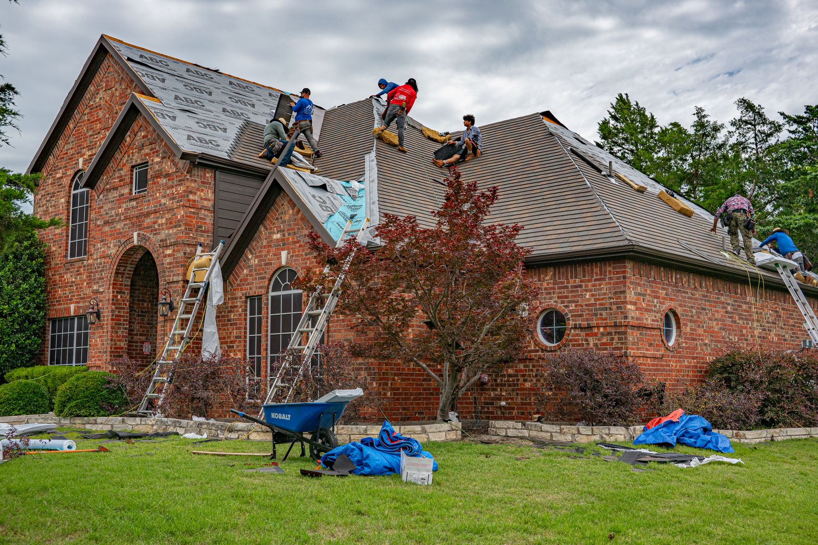 Roofer fitting new shingles on a house