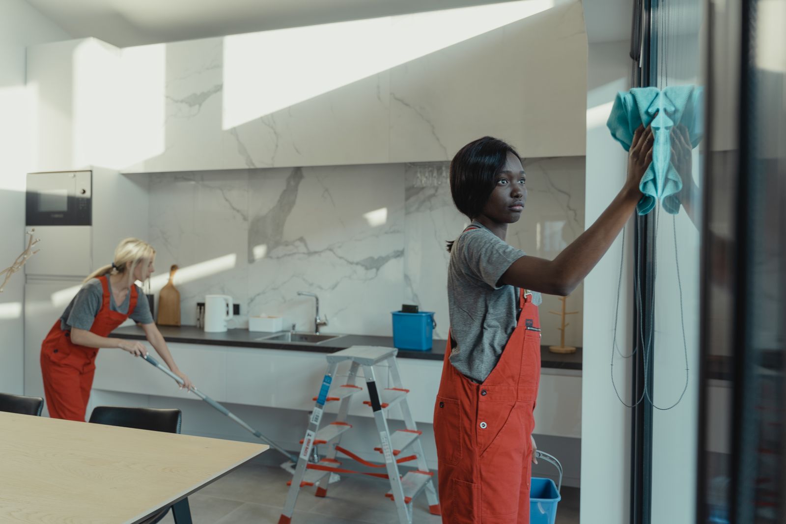 A cleaner with a spray bottle in a bright, tidy home