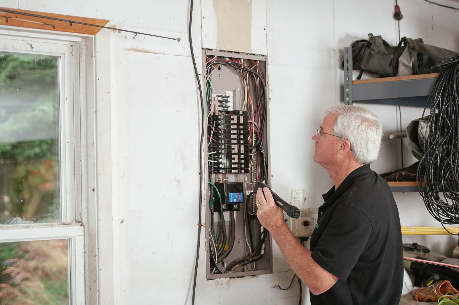 An electrician checking a breaker panel