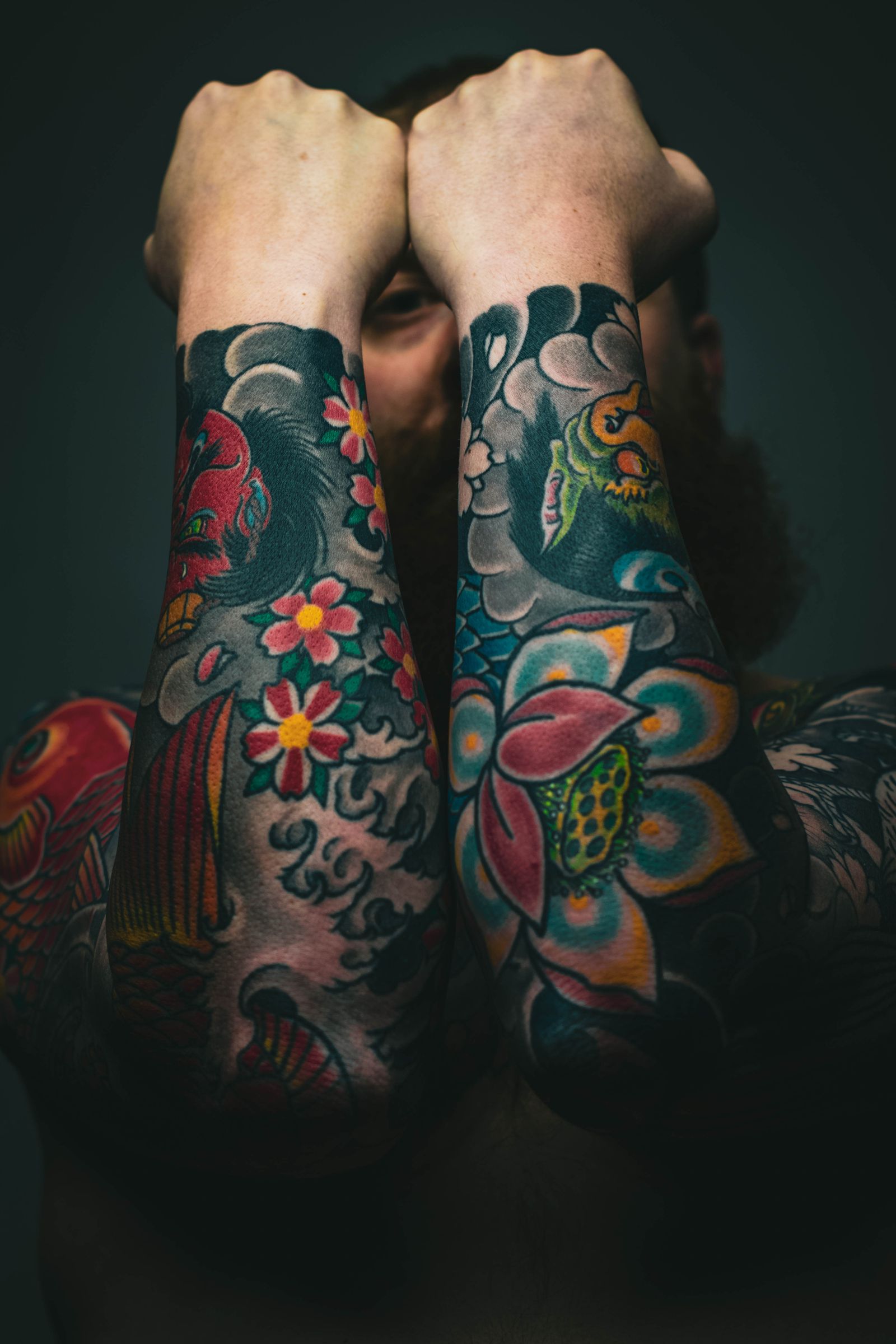 Colourful tattoo sleeves on two forearms