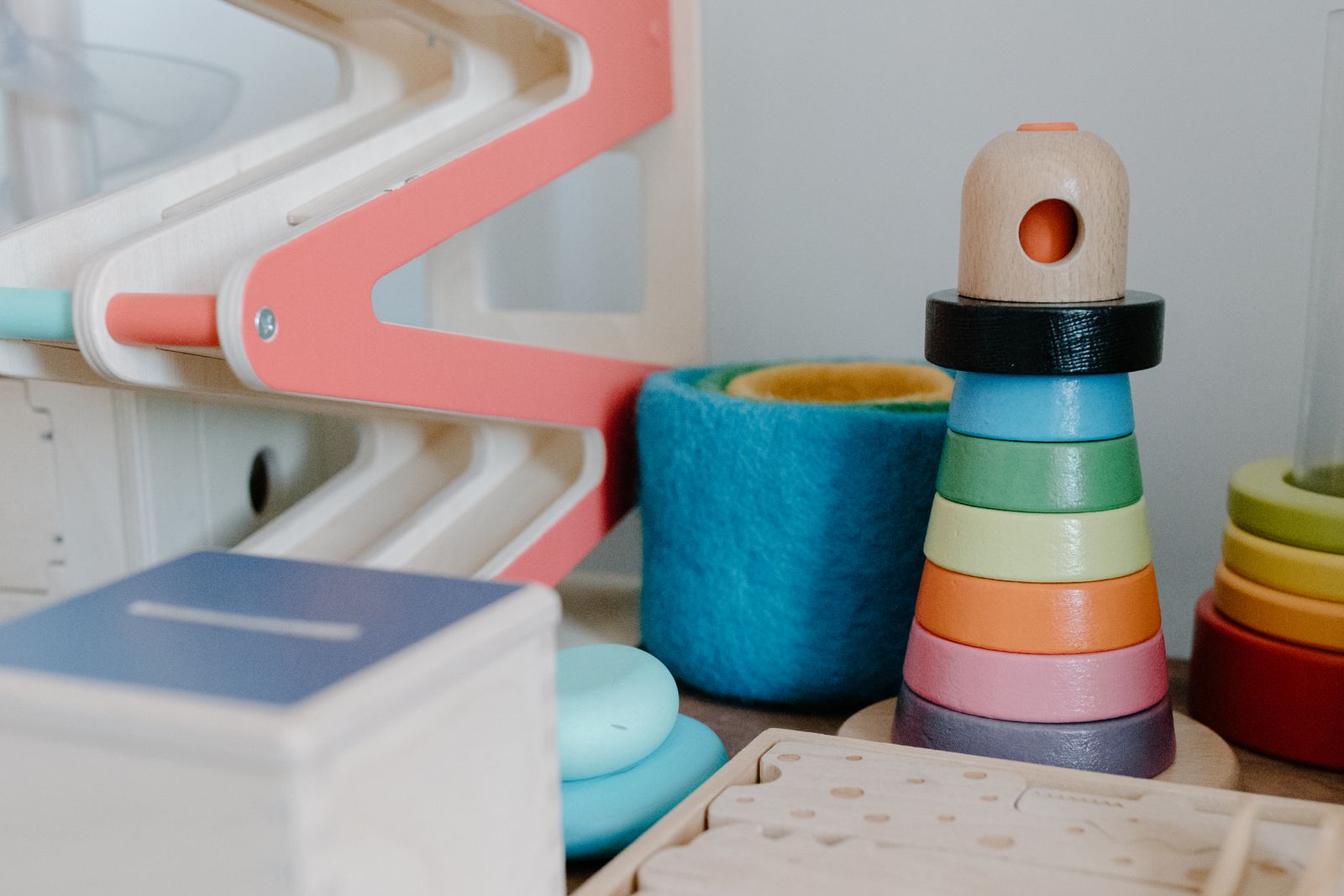 A bright play corner with stacking rings, blocks and a teddy bear