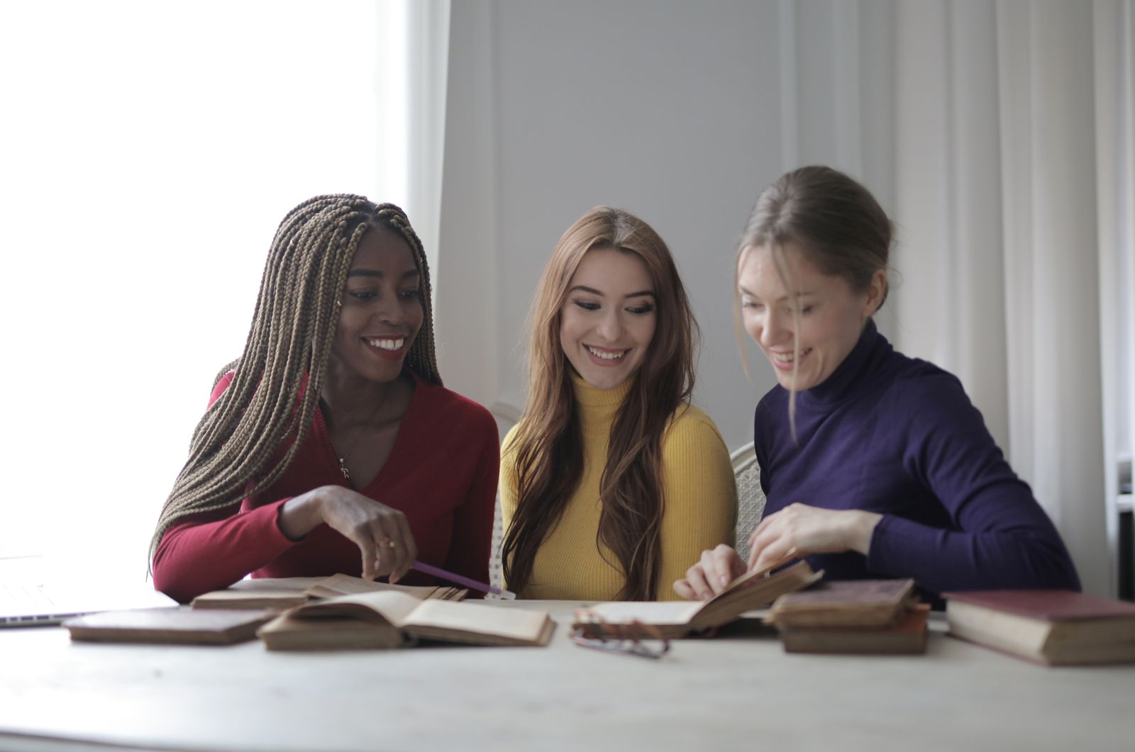 Readers around a table with books open and cups of tea