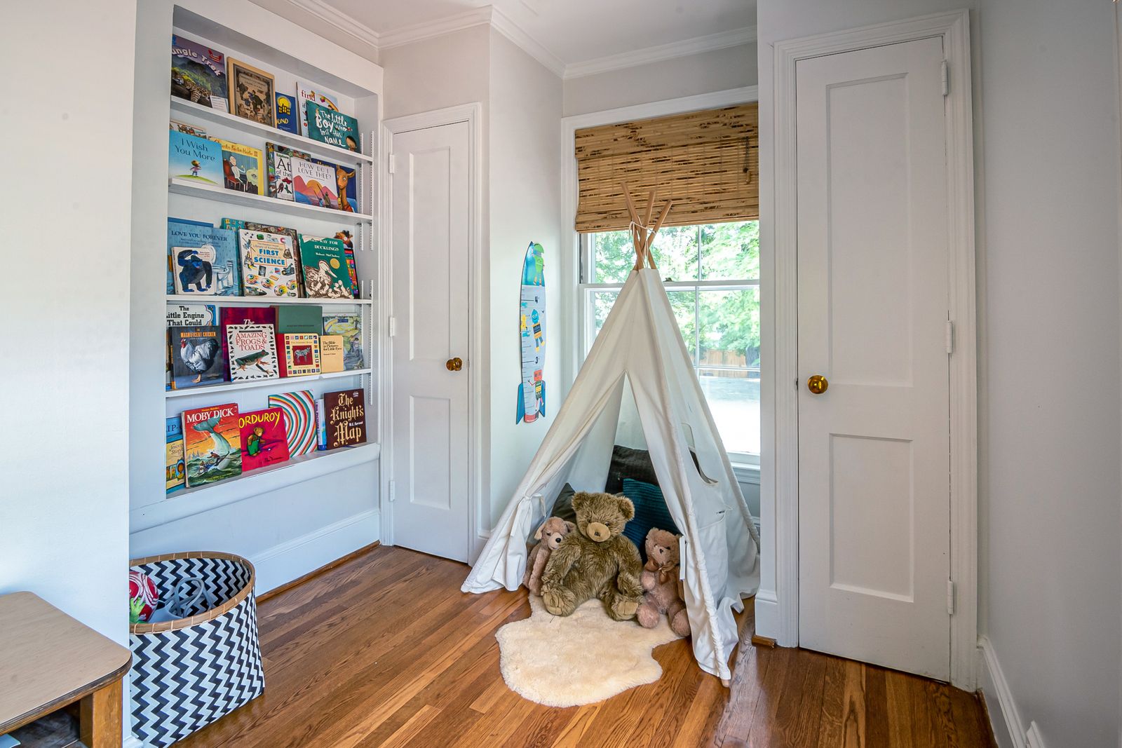 A children’s reading corner with low shelves of picture books and cushions