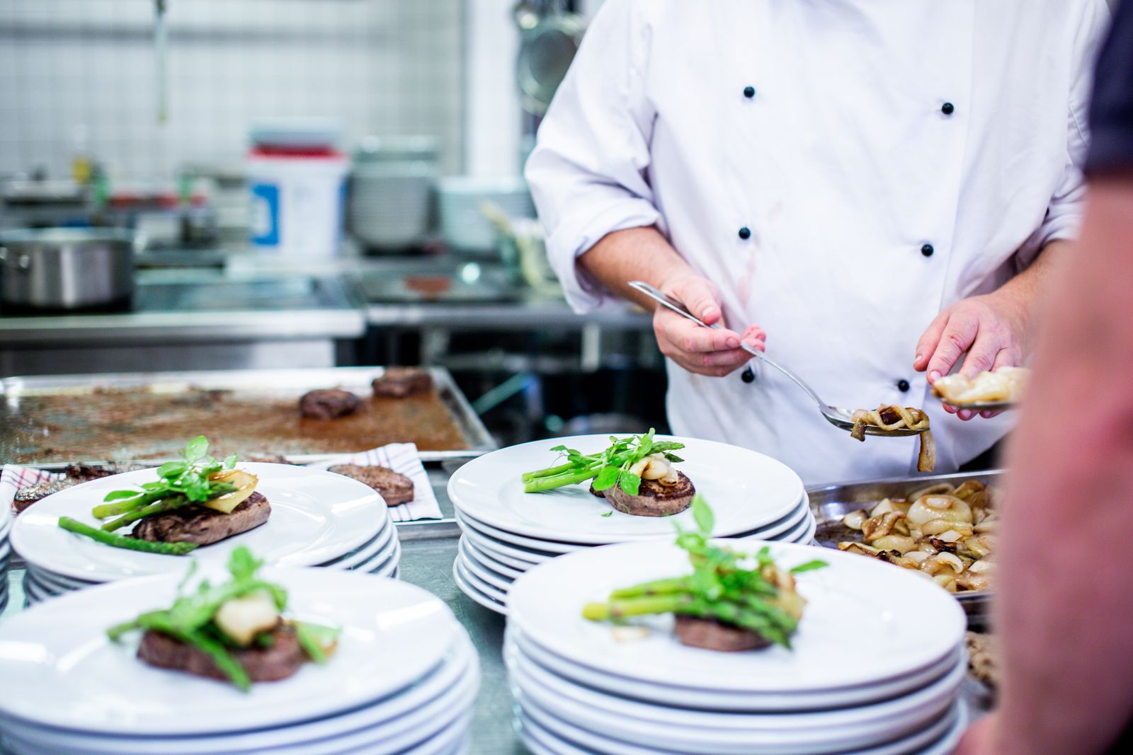 The chef cooking at the pass in the restaurant kitchen