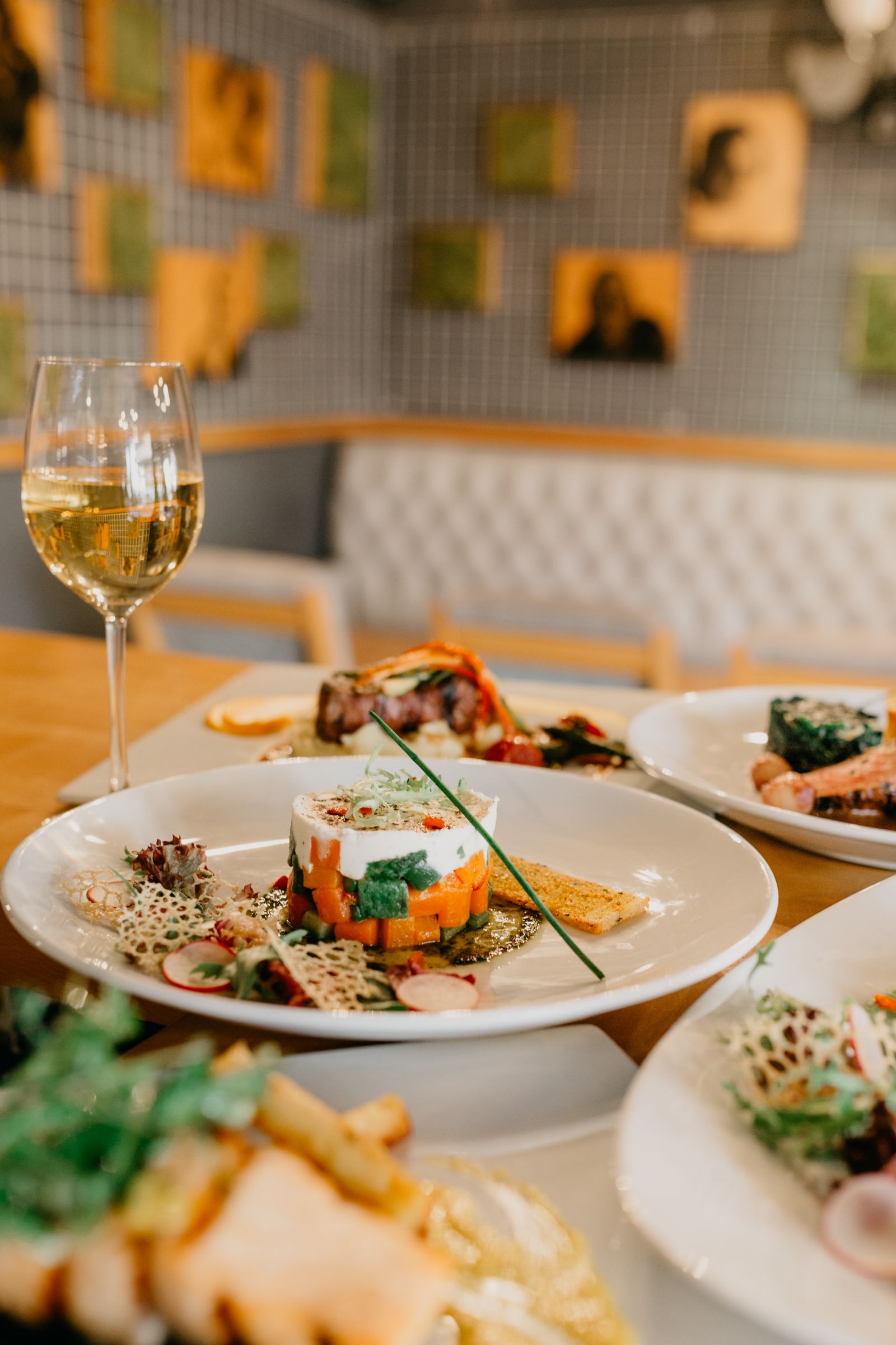 A plated main course and a glass of red wine on a dining table