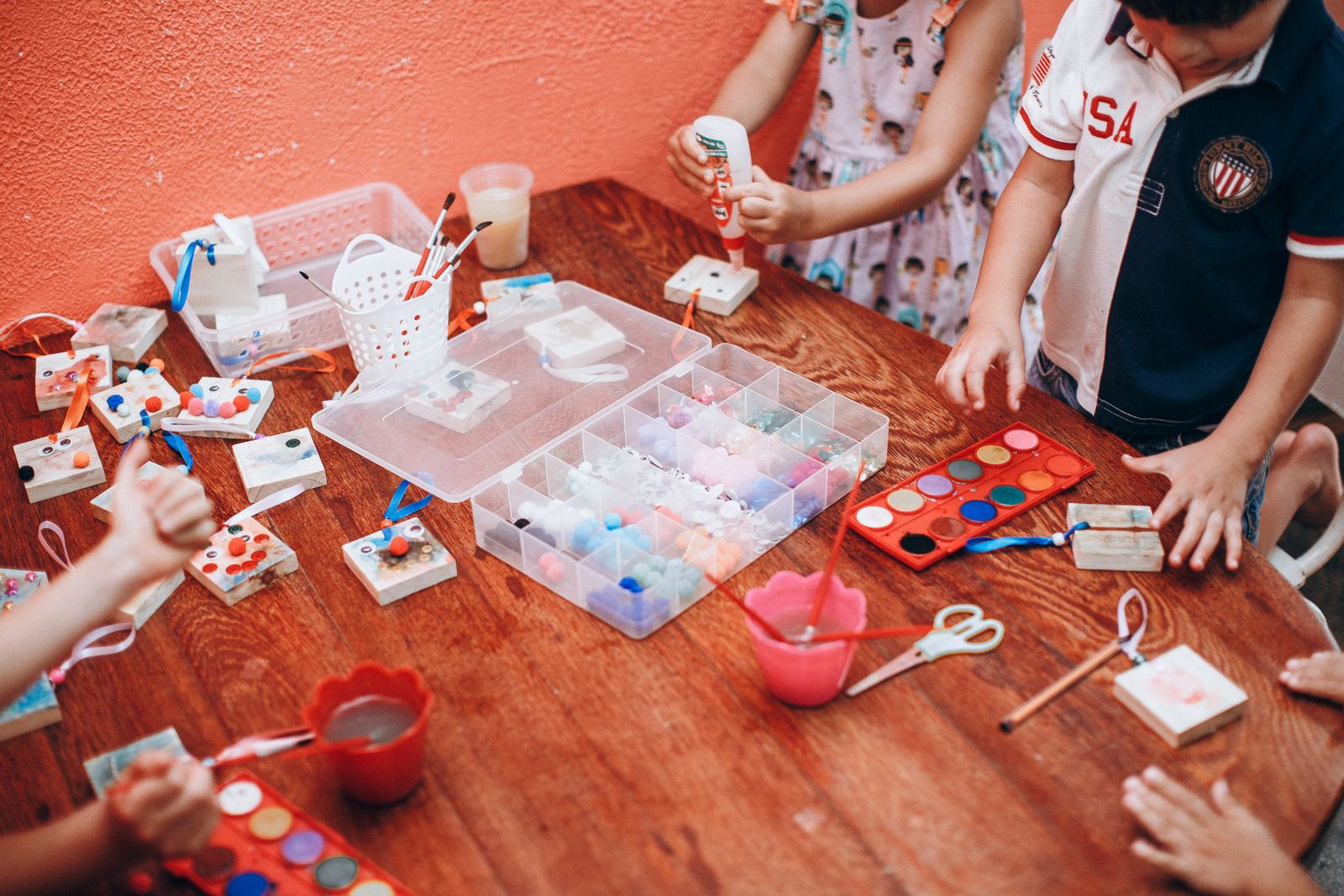 A craft table set out with paper, scissors and a pot of crayons