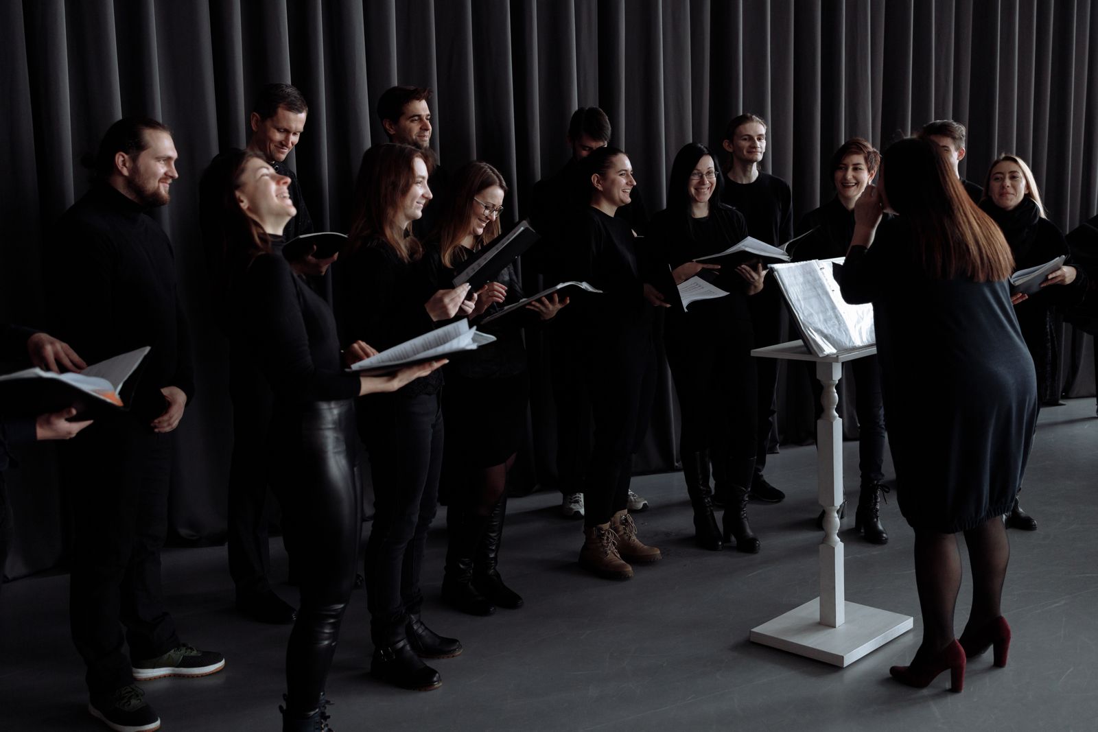 Choir members singing from open music folders