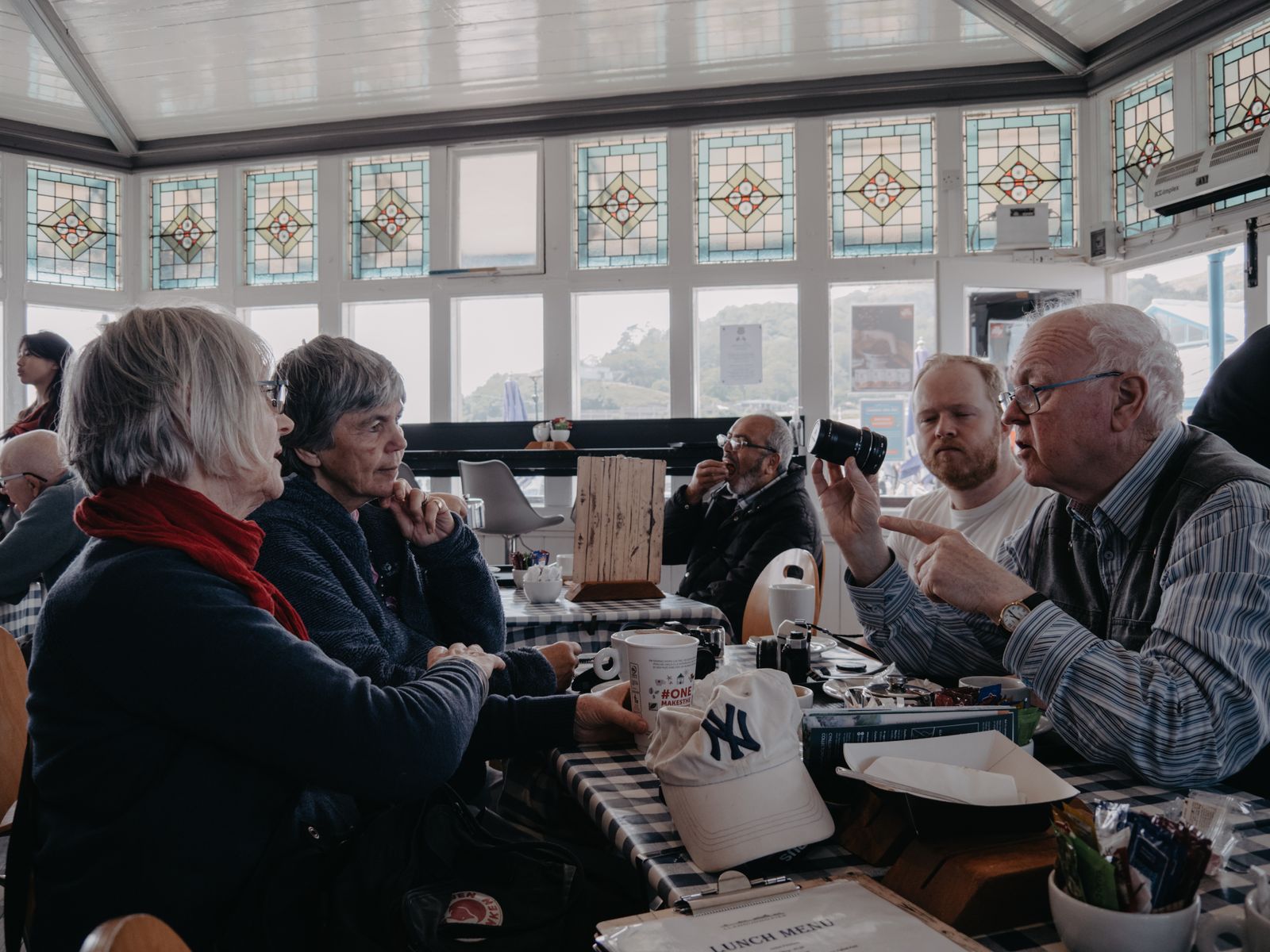 Two people talking over cups of coffee at a small table