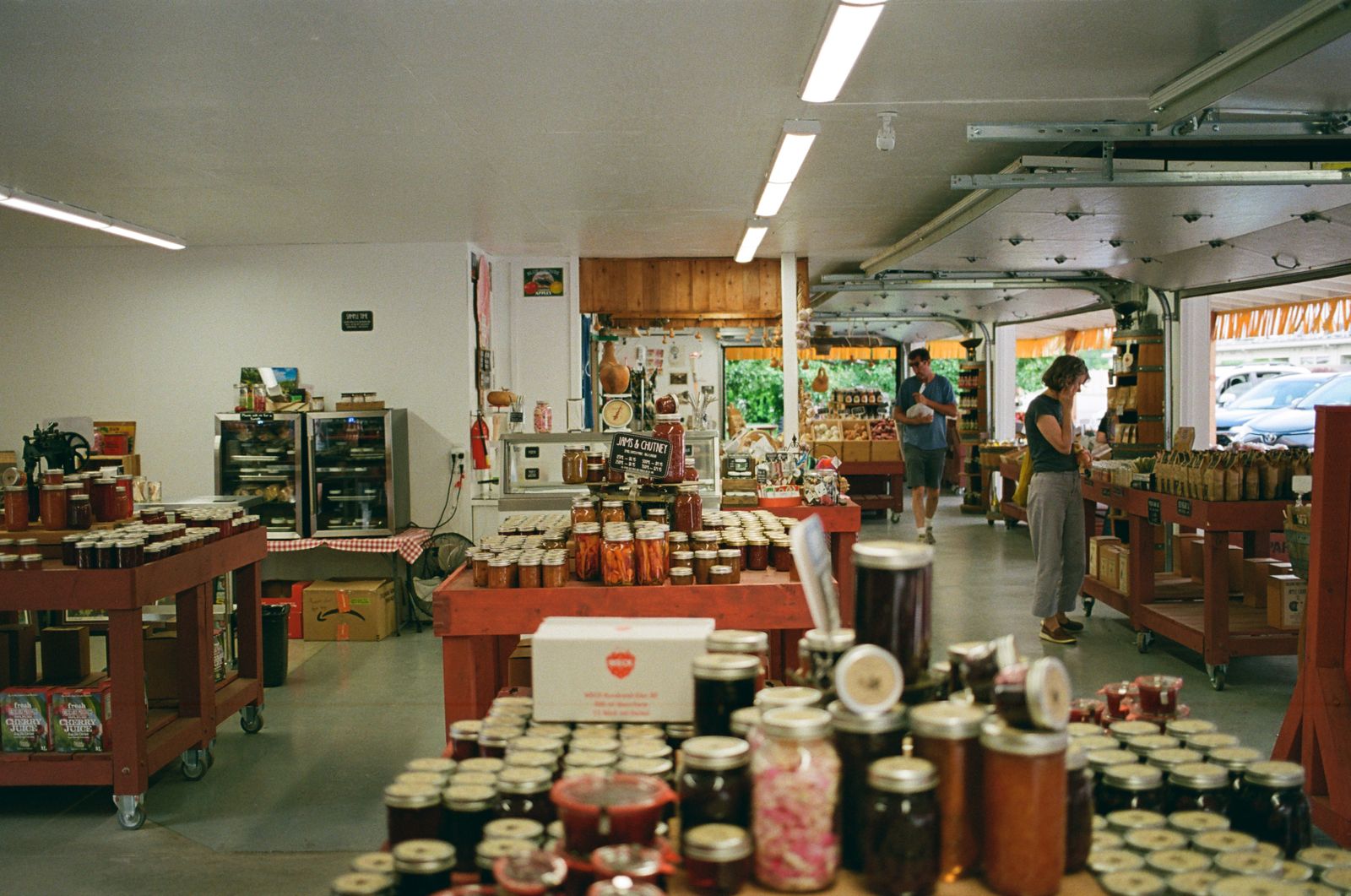 Shelves in the farm shop with crates of vegetables, eggs and jars