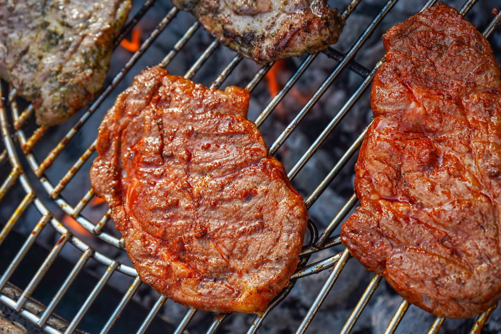 Steaks and sausages on a charcoal grill