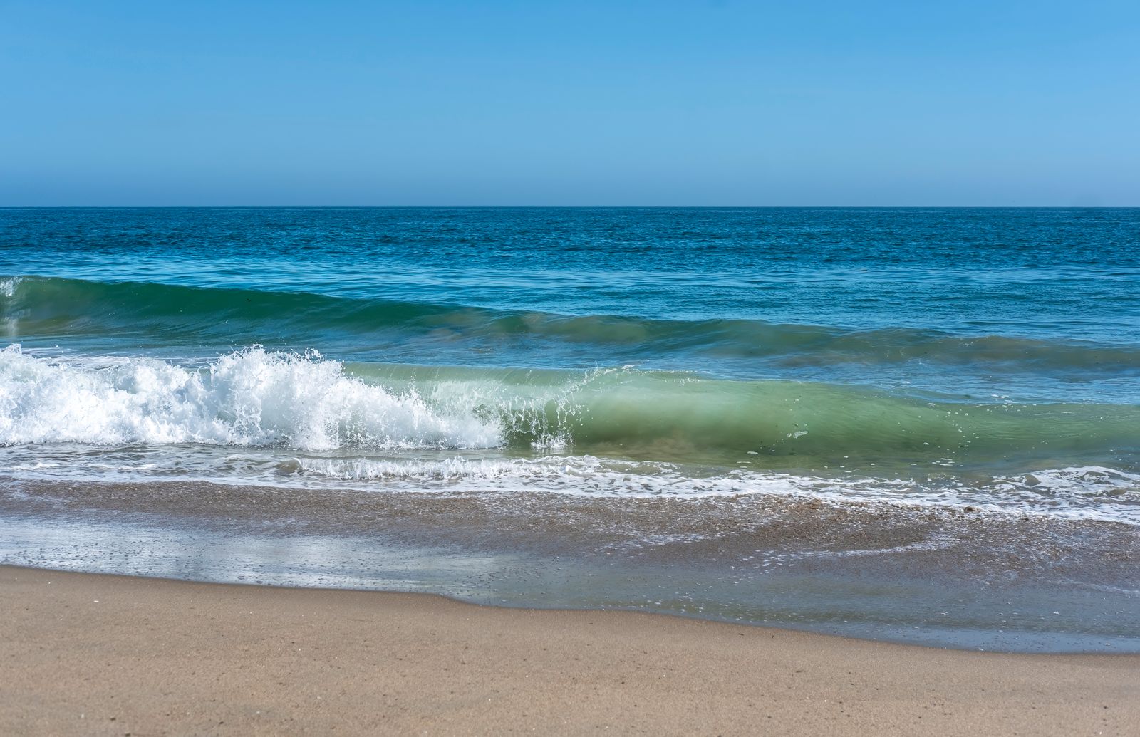 A small wave breaking towards the beach